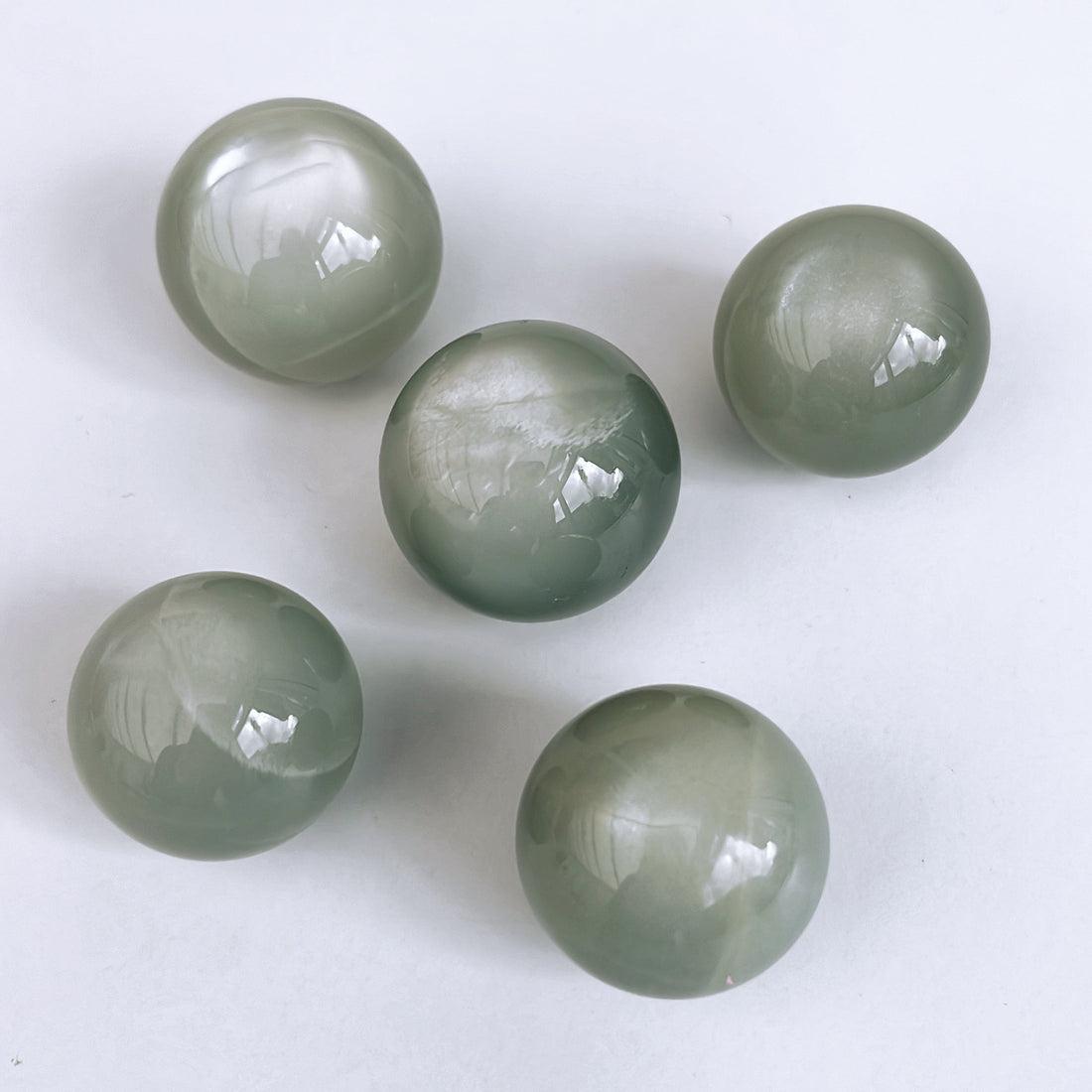 Unveiling the Enchantment: Silky Green Moonstone Spheres - Shiny Crystals